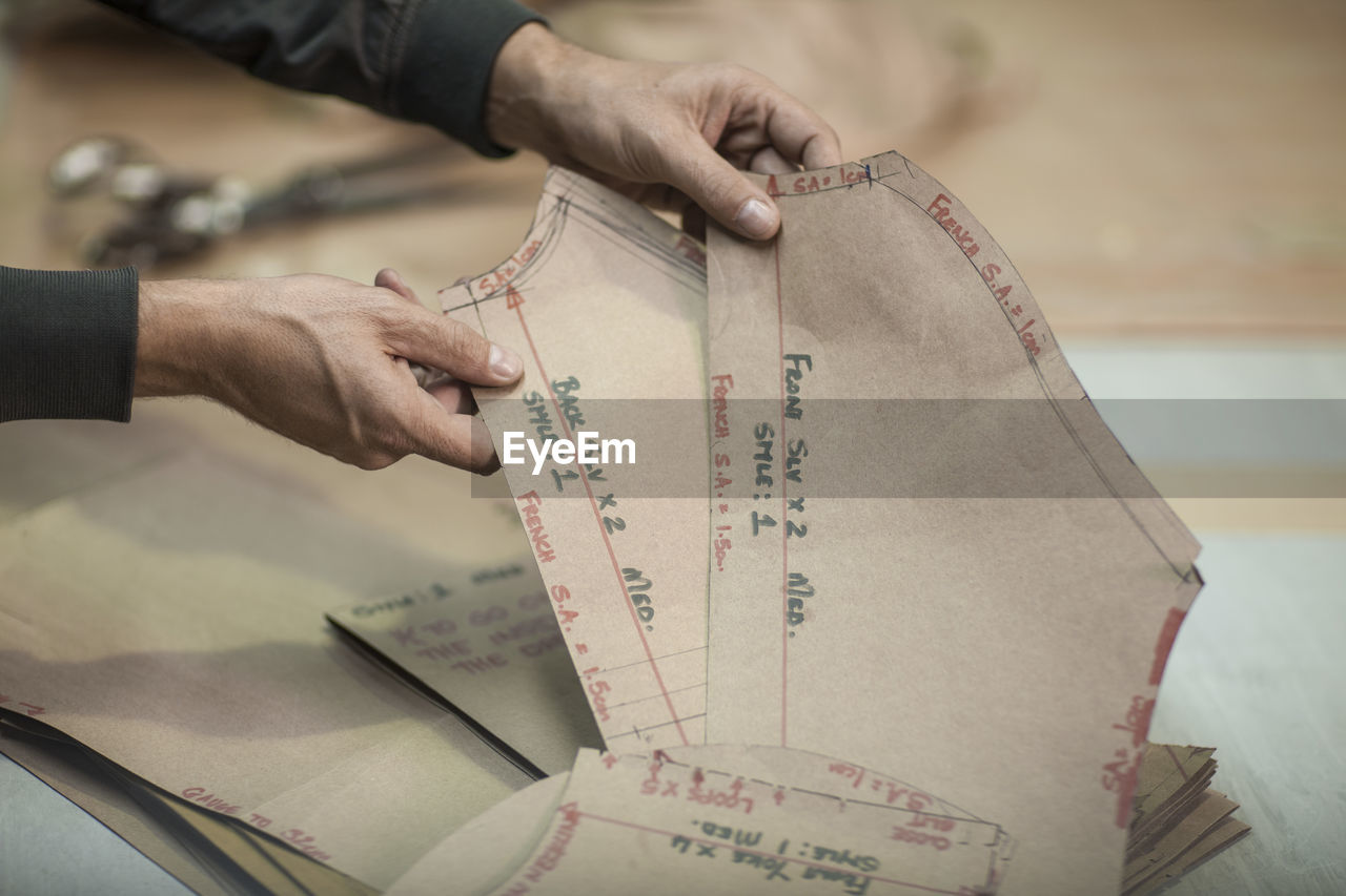 Tailor preparing cutting sheets in clothing factory