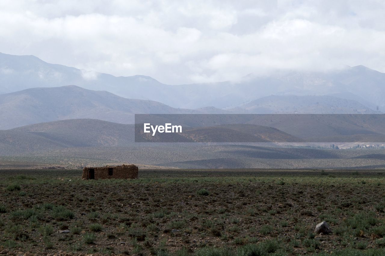 Scenic view of field and mountains against sky