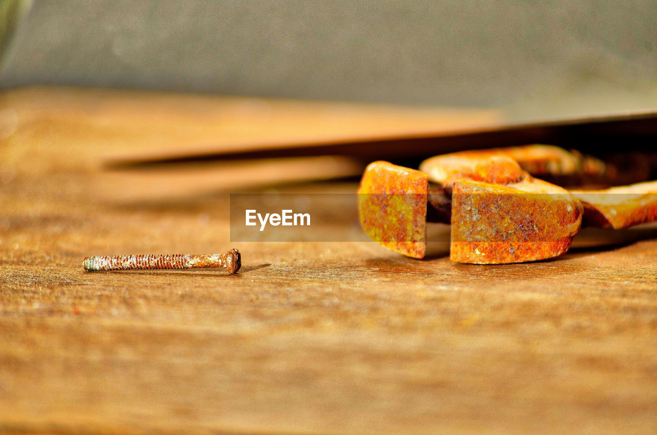 Close-up of old rusty metal screw on table