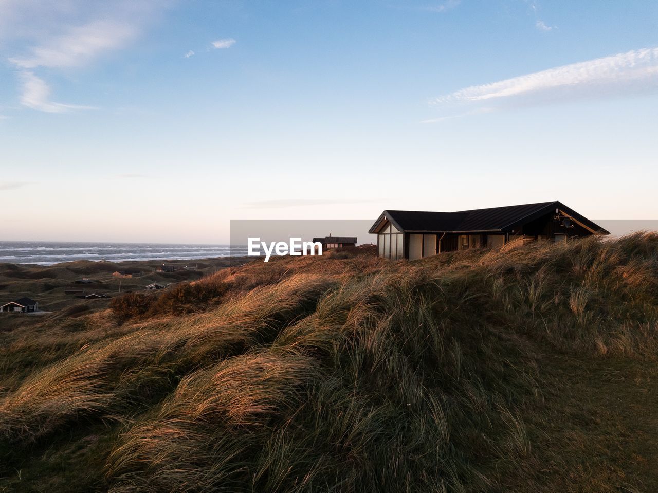 House on beach by sea against sky