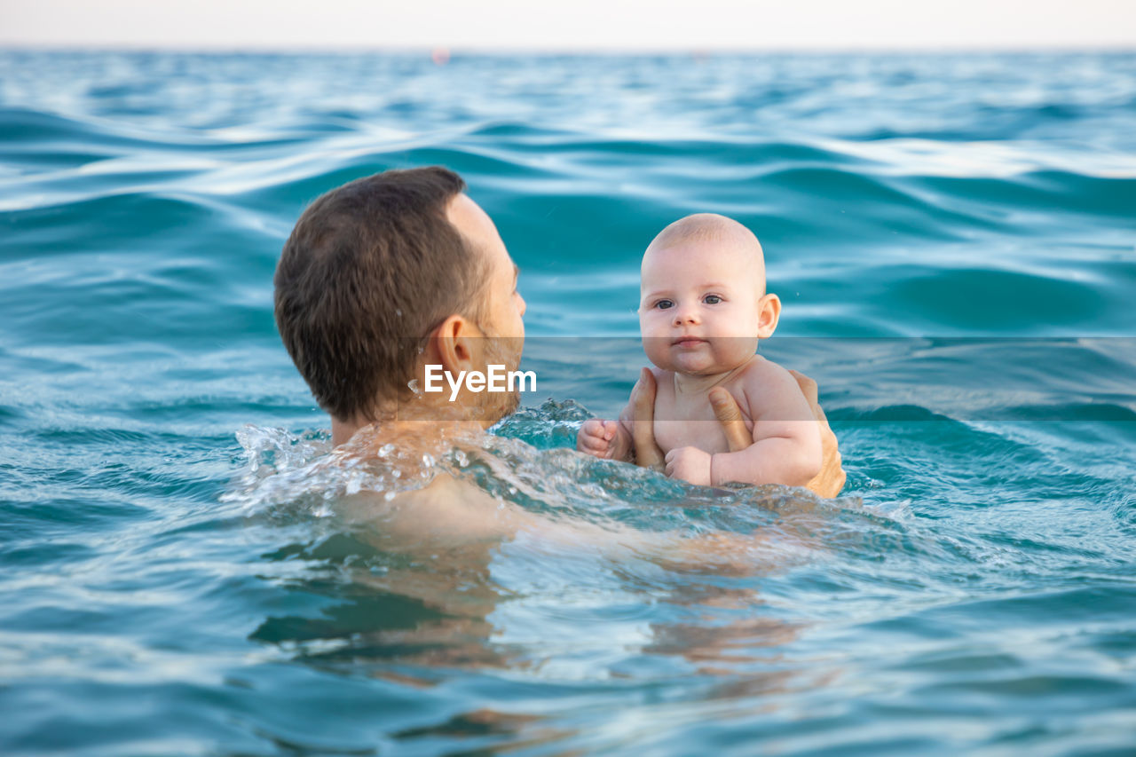 Portrait of shirtless boy swimming in pool