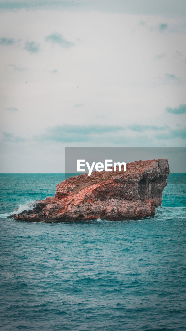 SCENIC VIEW OF ROCKS IN SEA AGAINST SKY