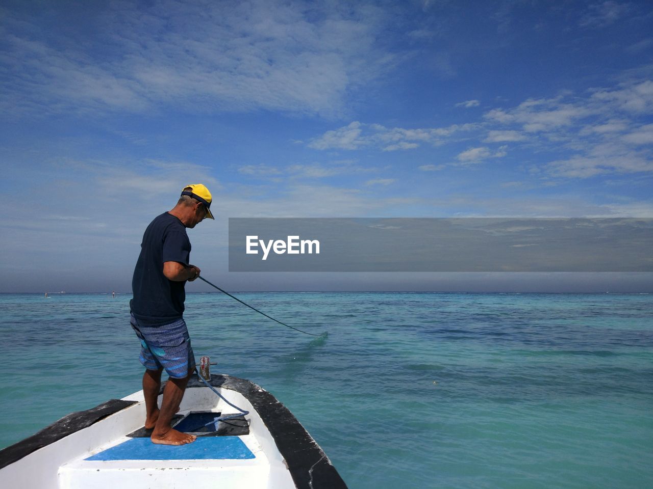 Full length of man fishing in sea against sky