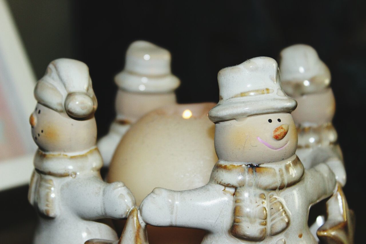 Figurines of snowmen around candle