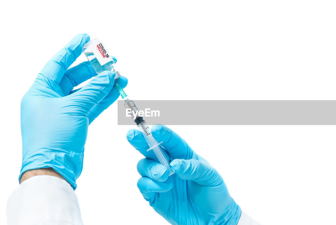 Doctor or scientist hand in white gloves holding flu, measles, coronavirus vaccine shot