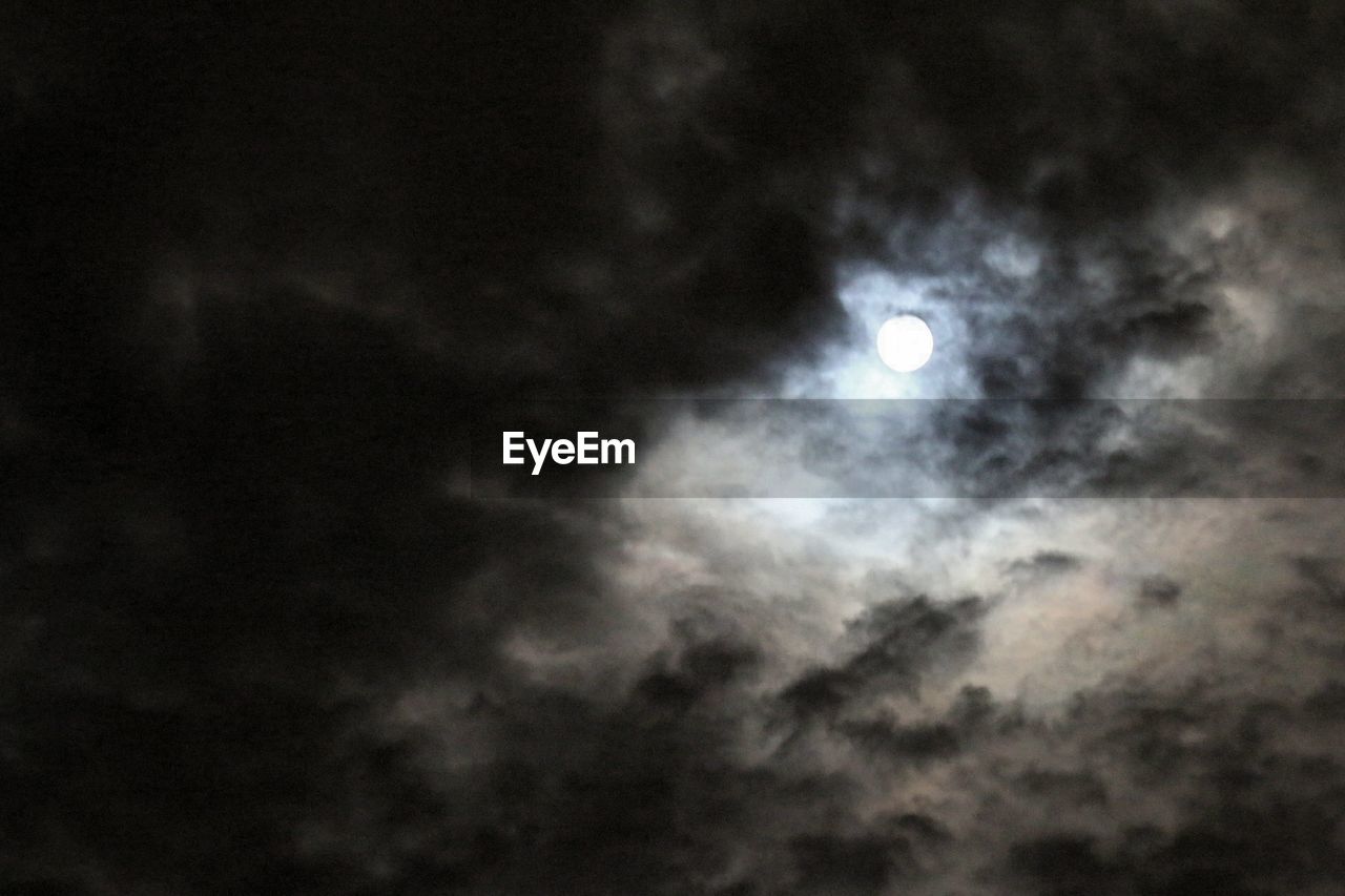 LOW ANGLE VIEW OF MOON IN CLOUDY SKY