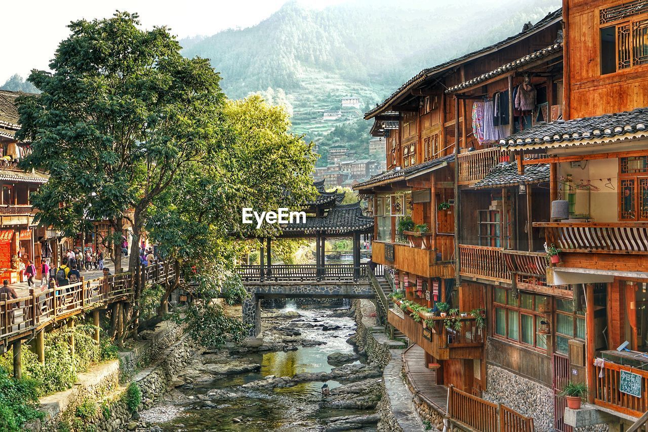 BUILDINGS BY RIVER AGAINST SKY