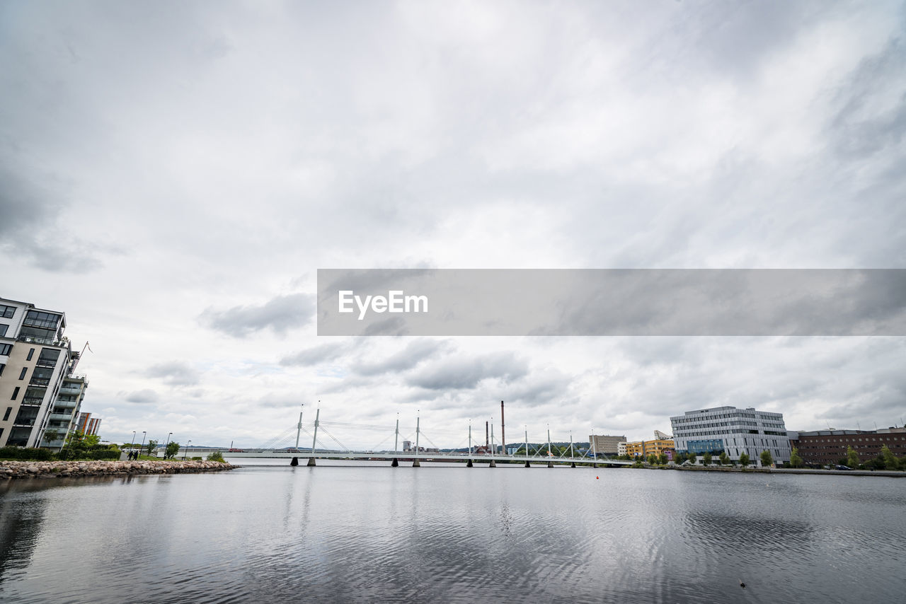 Bridge over river against buildings in city