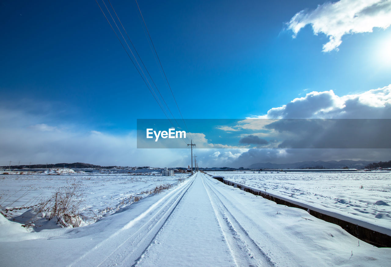 Snow covered landscape against sky