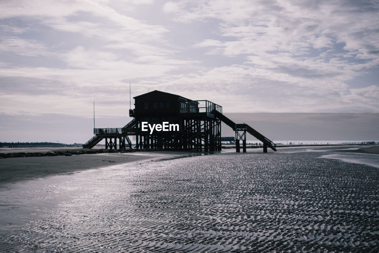 PIER ON BEACH AGAINST SKY