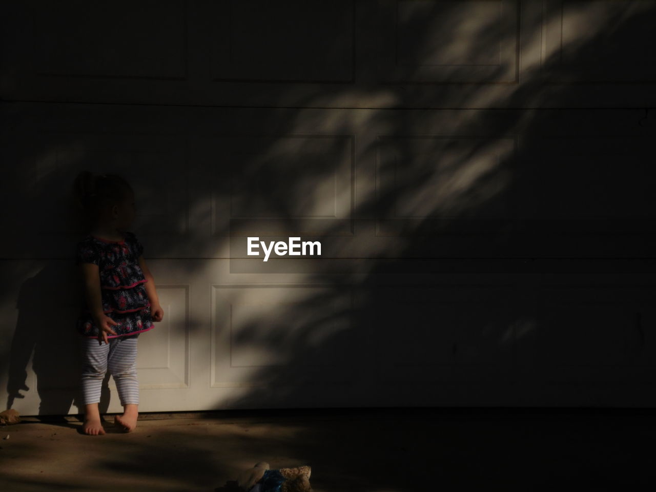 Full length of girl standing against wall in home