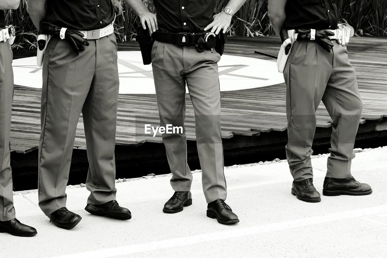 Low section of police officers standing on footpath