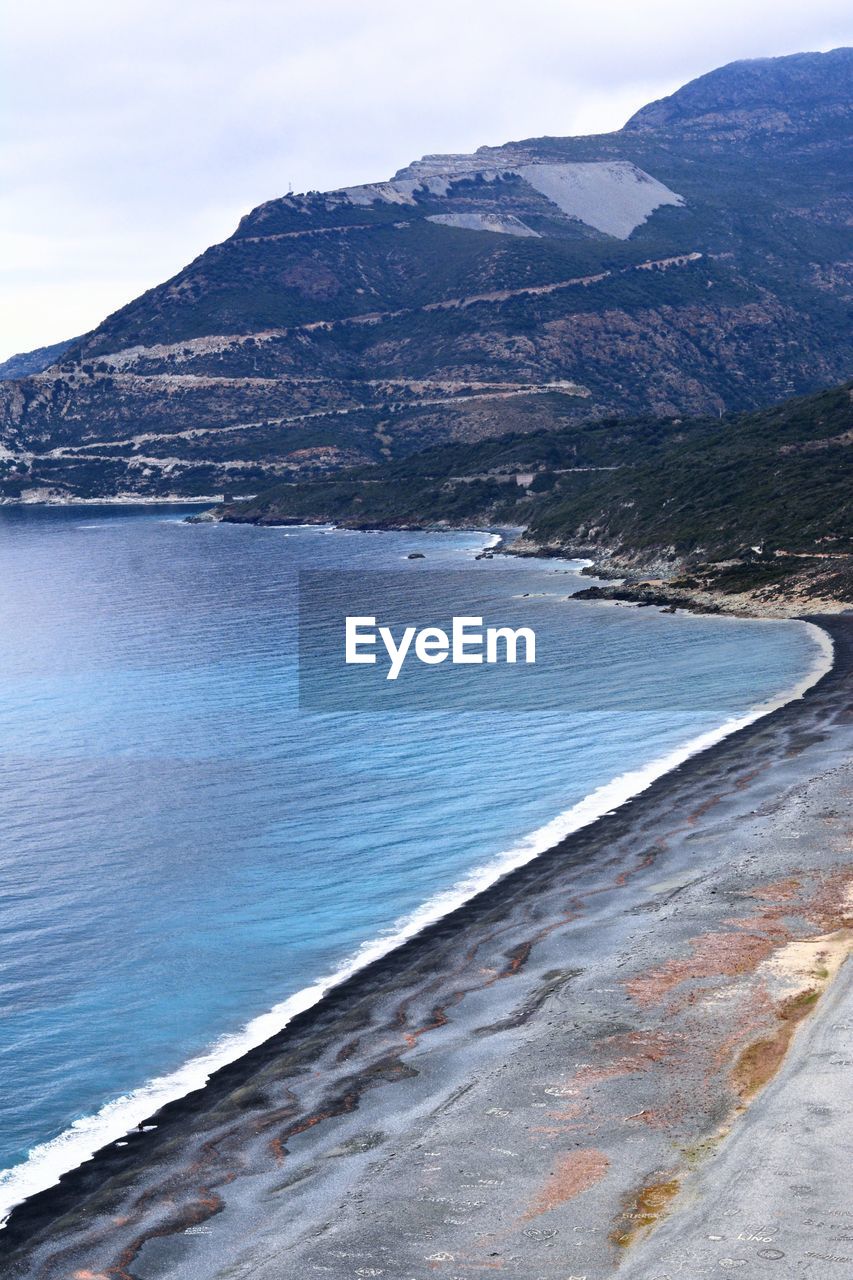 Scenic view of sea and mountains against sky