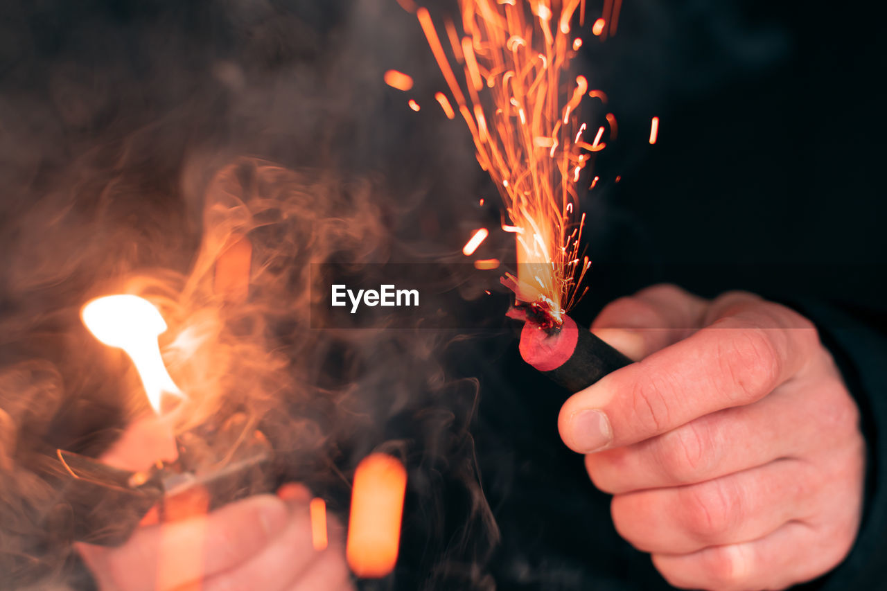 CROPPED IMAGE OF HAND HOLDING SPARKLER