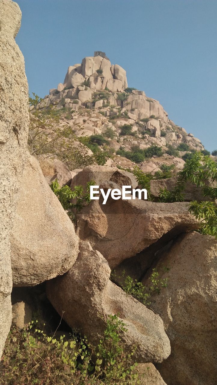 Low angle view of rocks against clear sky