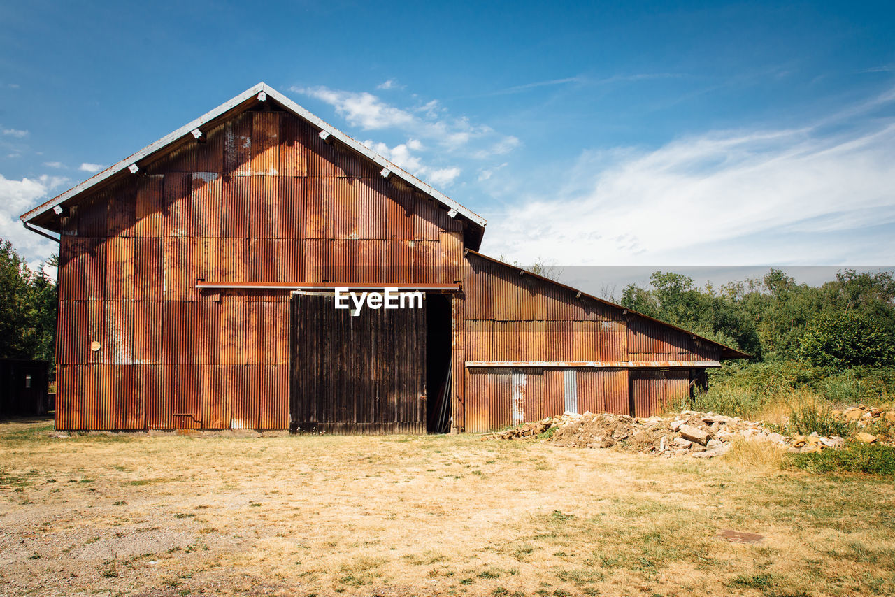 Abandoned building on field against sky