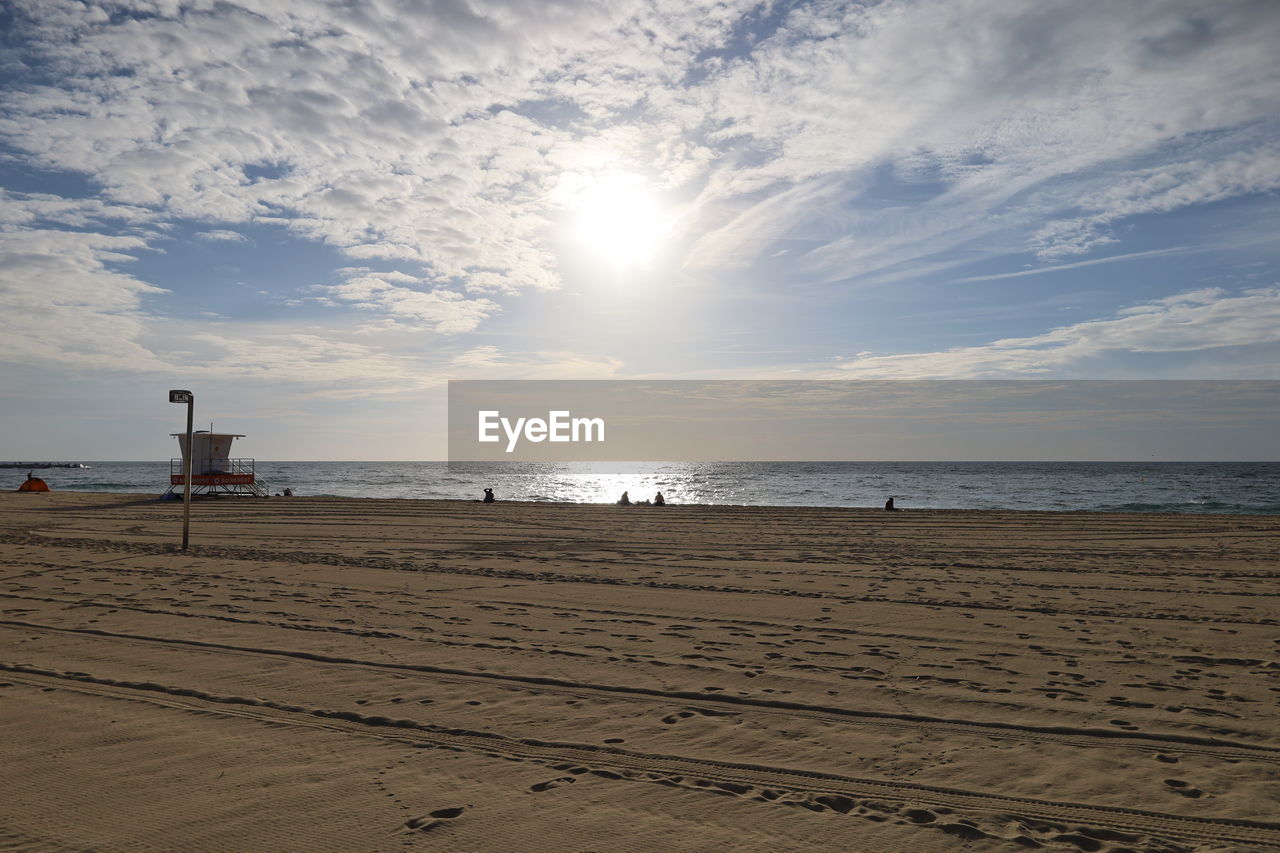 sea, beach, sky, land, water, sand, horizon, body of water, nature, horizon over water, ocean, scenics - nature, cloud, beauty in nature, shore, coast, tranquility, wave, sunset, sun, tranquil scene, sunlight, holiday, travel destinations, vacation, architecture, trip, travel, coastline, outdoors, hut, built structure, tourism, day, seascape, no people, idyllic, lifeguard hut, environment, summer, tower, dusk, man made structure
