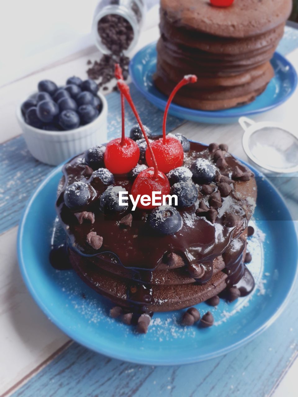 High angle view of cherries and blueberries on chocolate pancakes