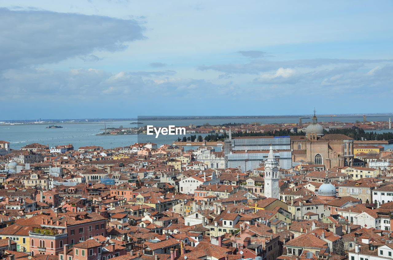 HIGH ANGLE VIEW OF TOWNSCAPE AGAINST SEA