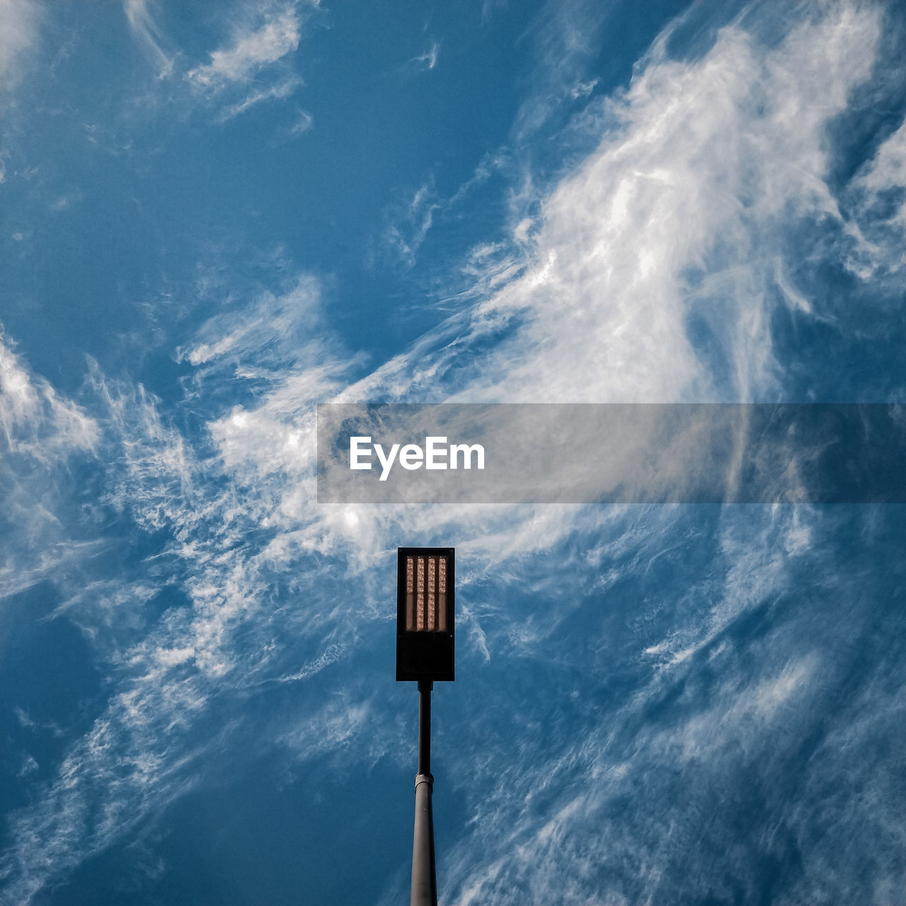 Centred lightpost with swirly clouds for a background