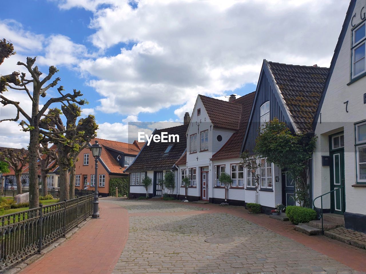 STREET AMIDST HOUSES AGAINST BUILDINGS