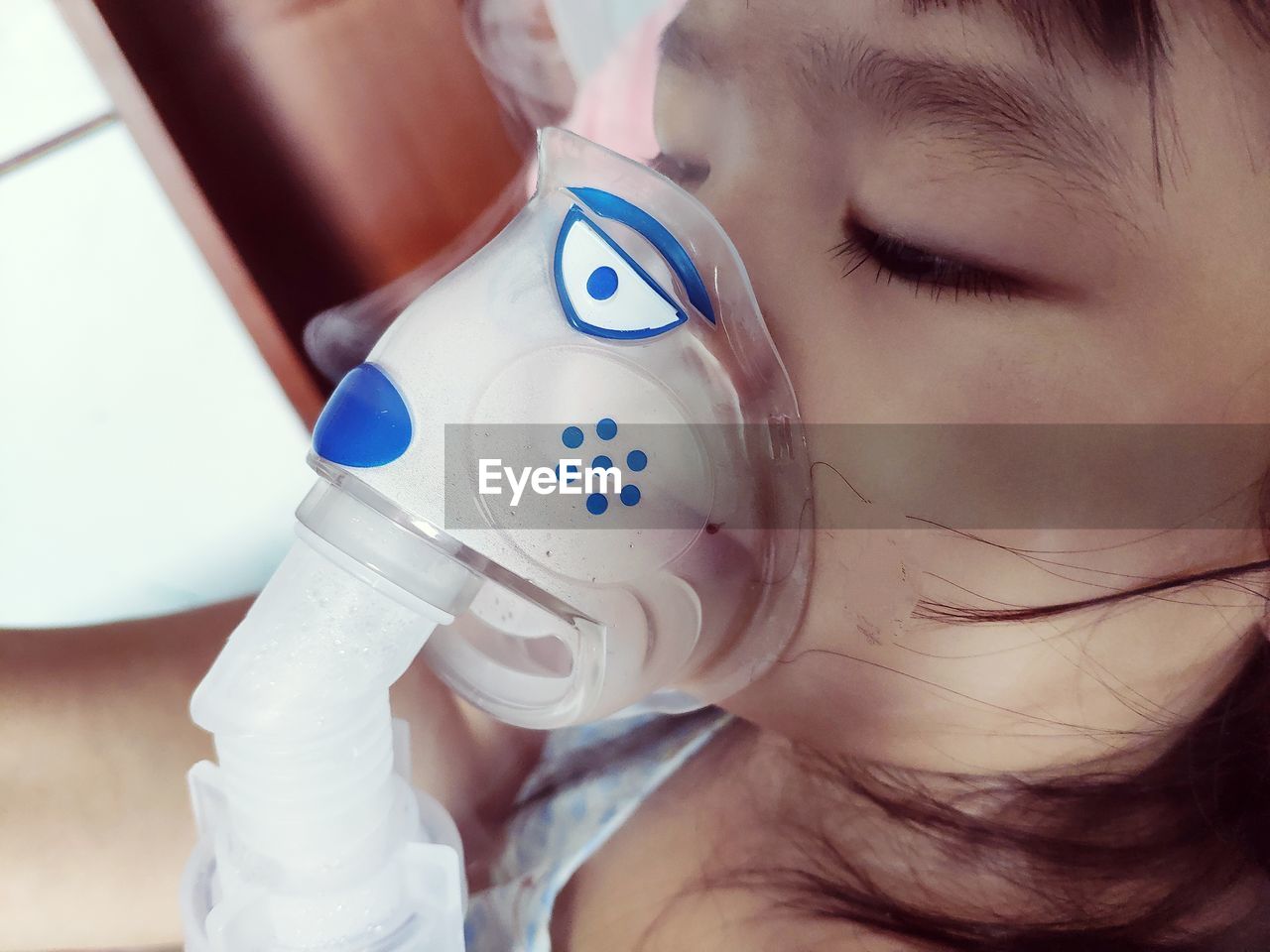 Close-up of girl with oxygen mask in hospital