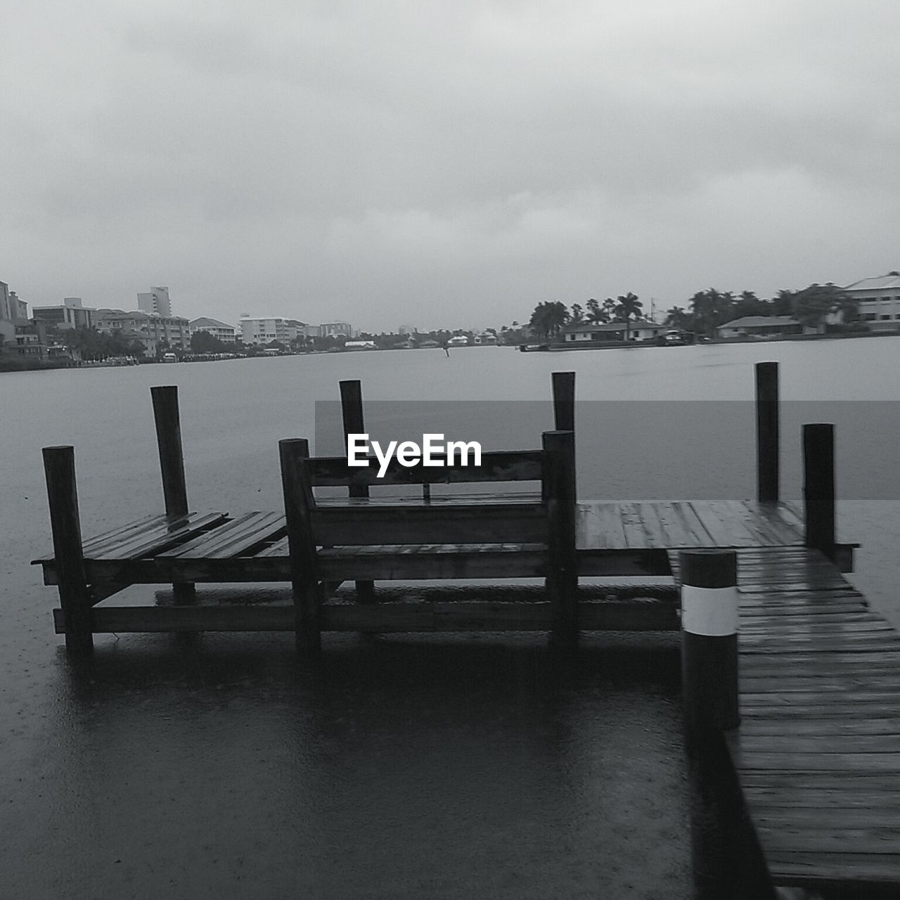 EMPTY BENCH ON PIER AGAINST SKY