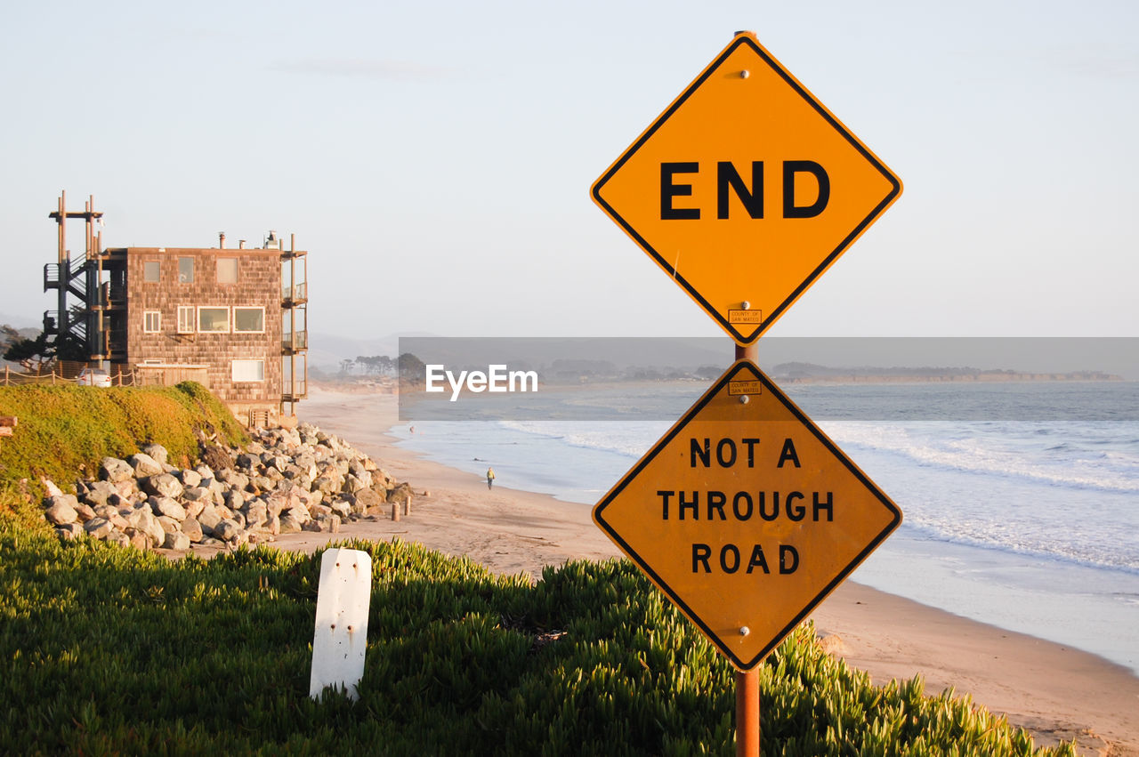 Close-up of road sign against beach
