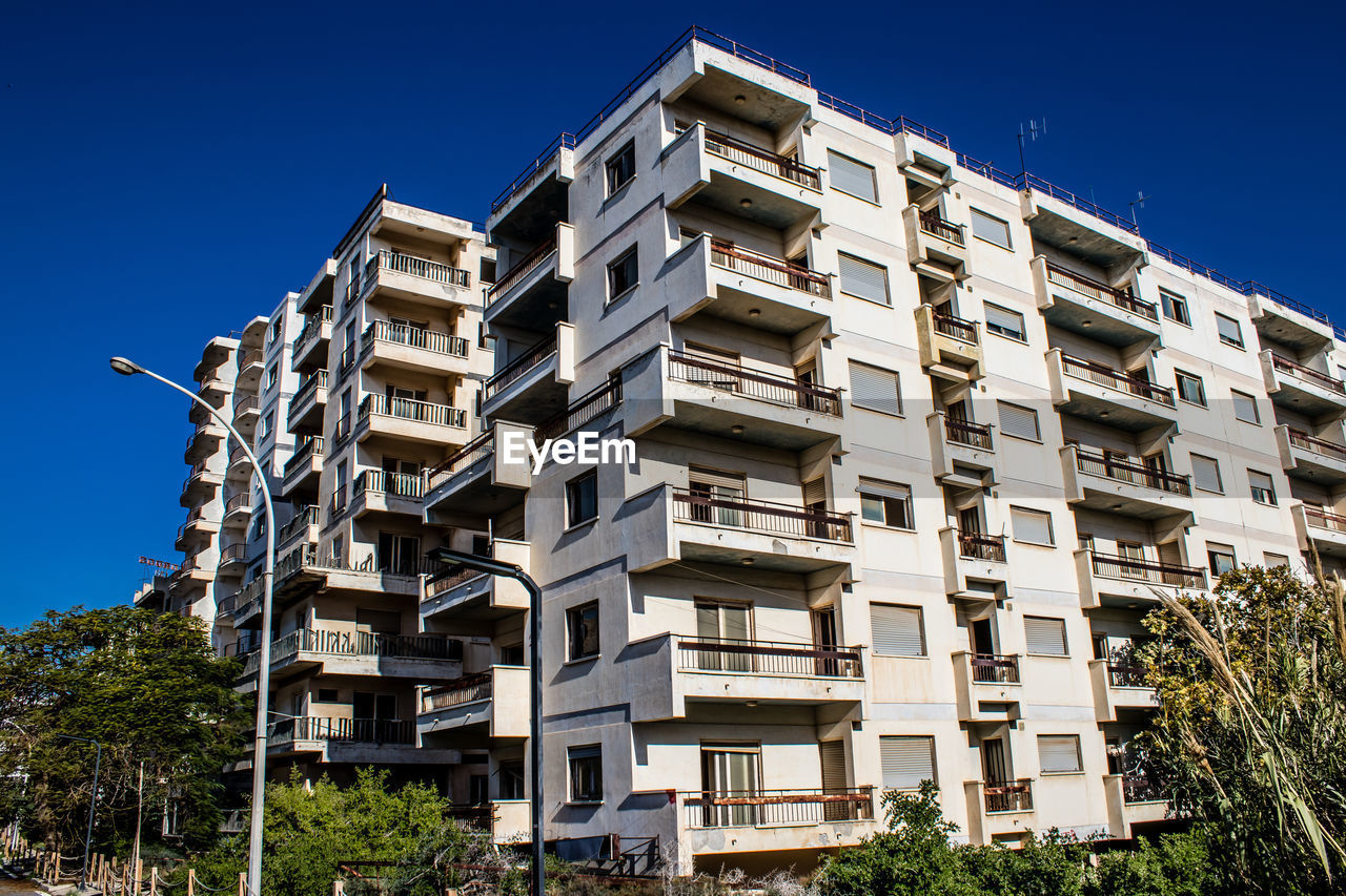 low angle view of buildings against clear blue sky