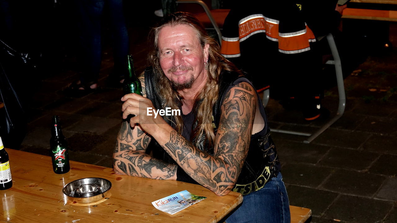 Portrait of man drinking alcohol while sitting in restaurant