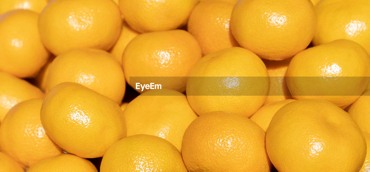 FULL FRAME SHOT OF ORANGES IN MARKET FOR SALE