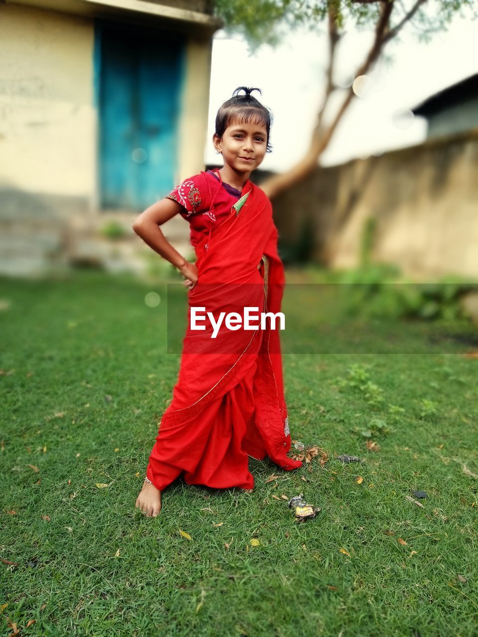 Portrait of smiling girl wearing sari standing in yard