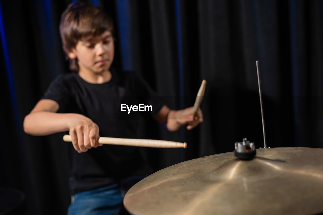 portrait of young man playing drum at home