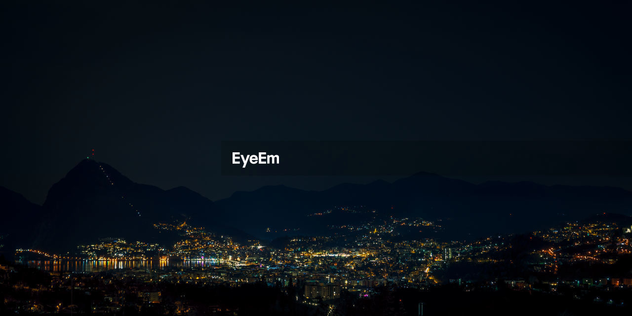 High angle view of illuminated city against sky at night