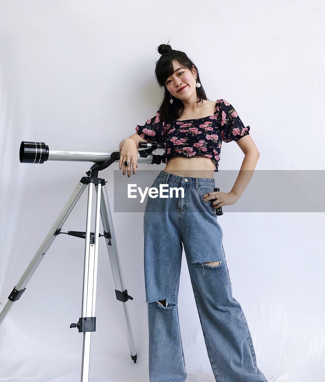 Portrait of woman standing next to telescope 