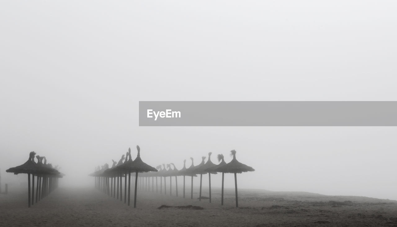 STILT HOUSE ON BEACH AGAINST CLEAR SKY