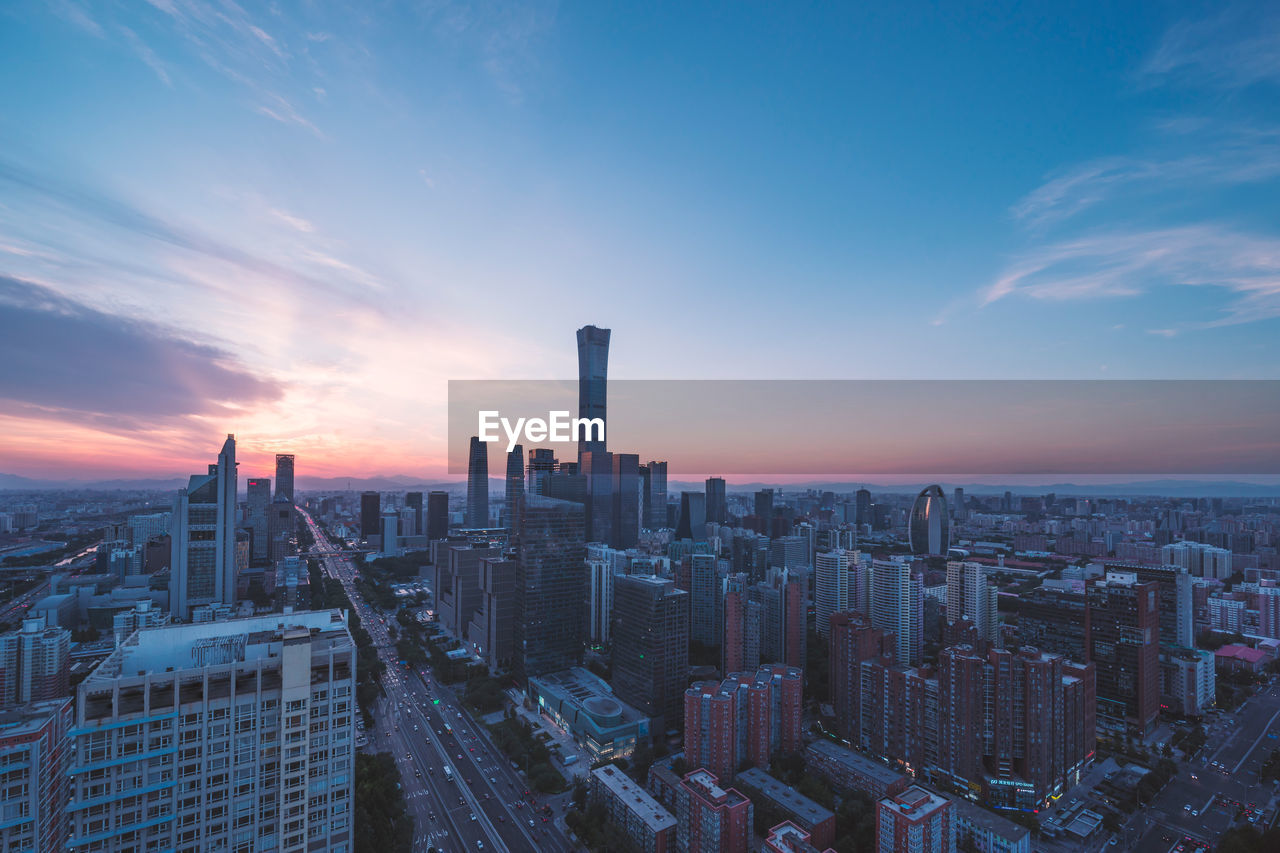 Aerial view of buildings in city against sky during sunset