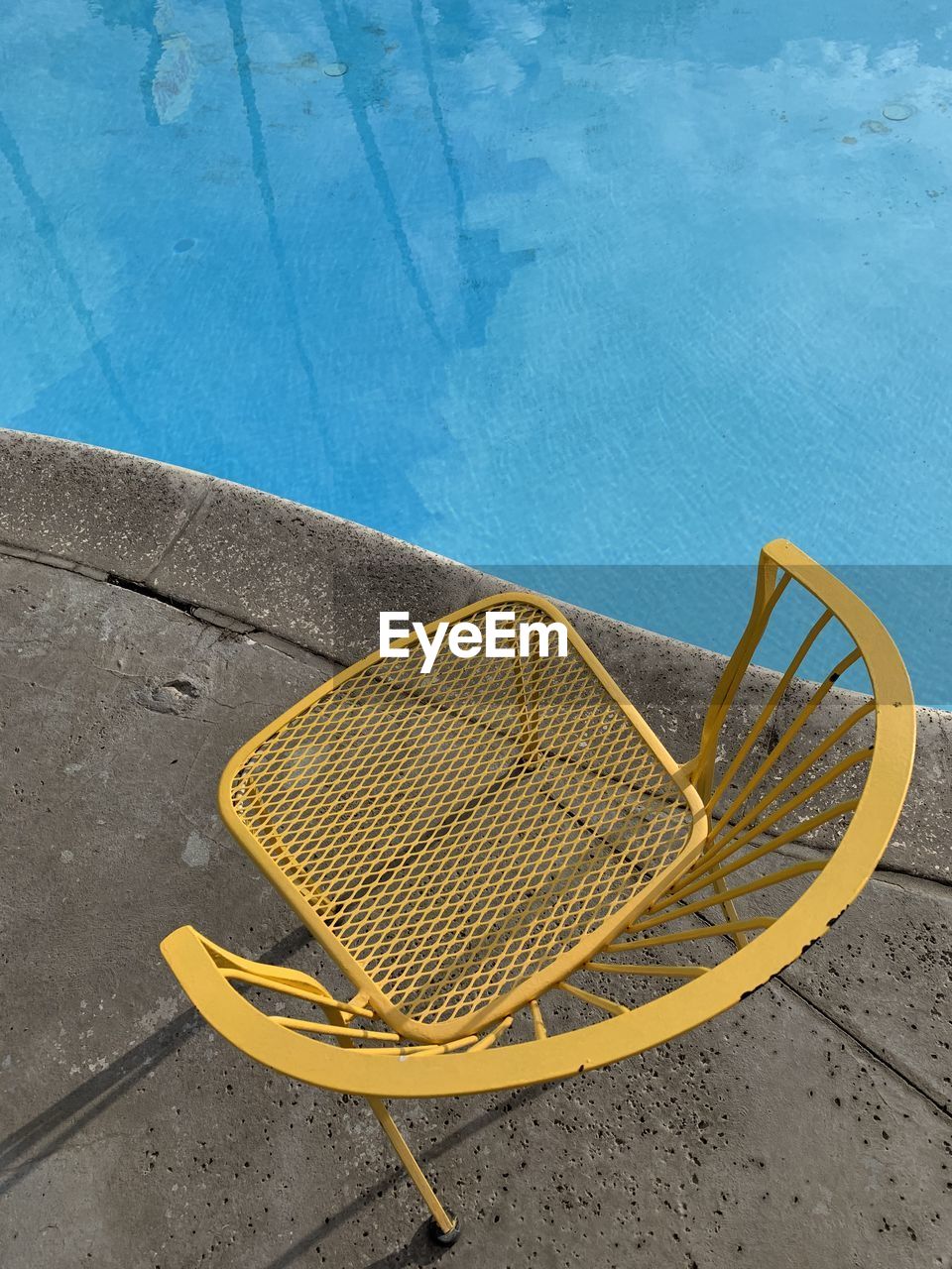 High angle view of empty chairs by swimming pool