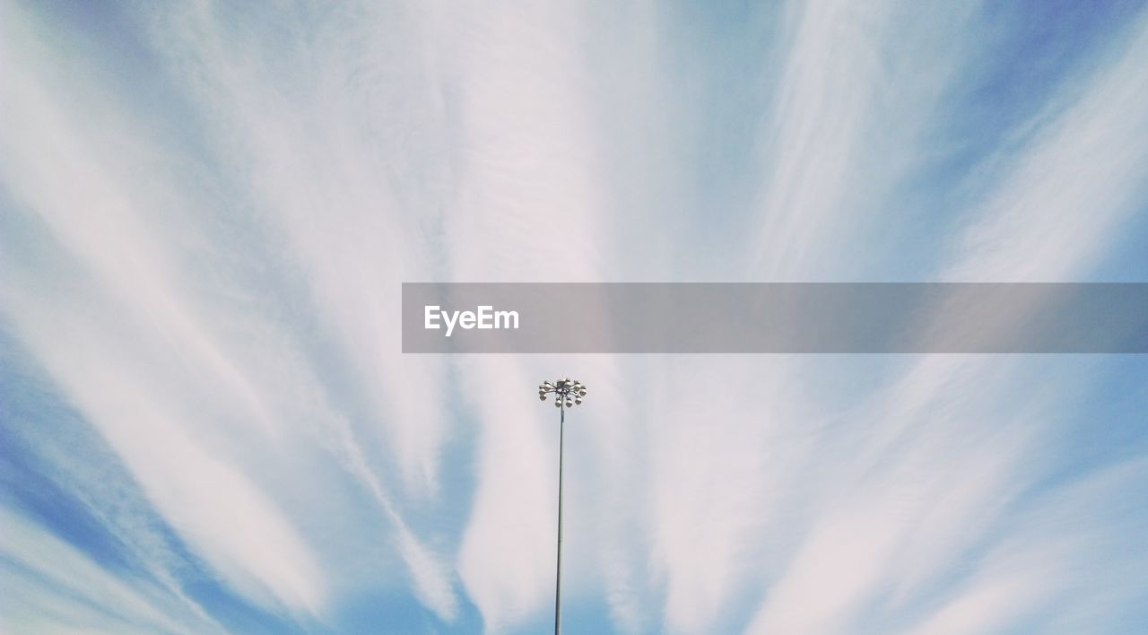 Low angle view of floodlight against cloudy sky