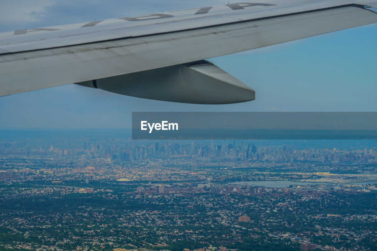 AIRPLANE FLYING OVER CITYSCAPE
