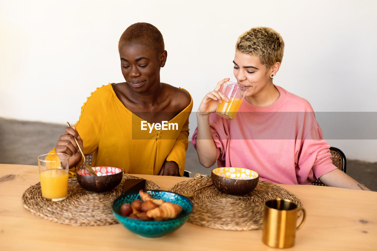 Lesbian couple eating breakfast at home