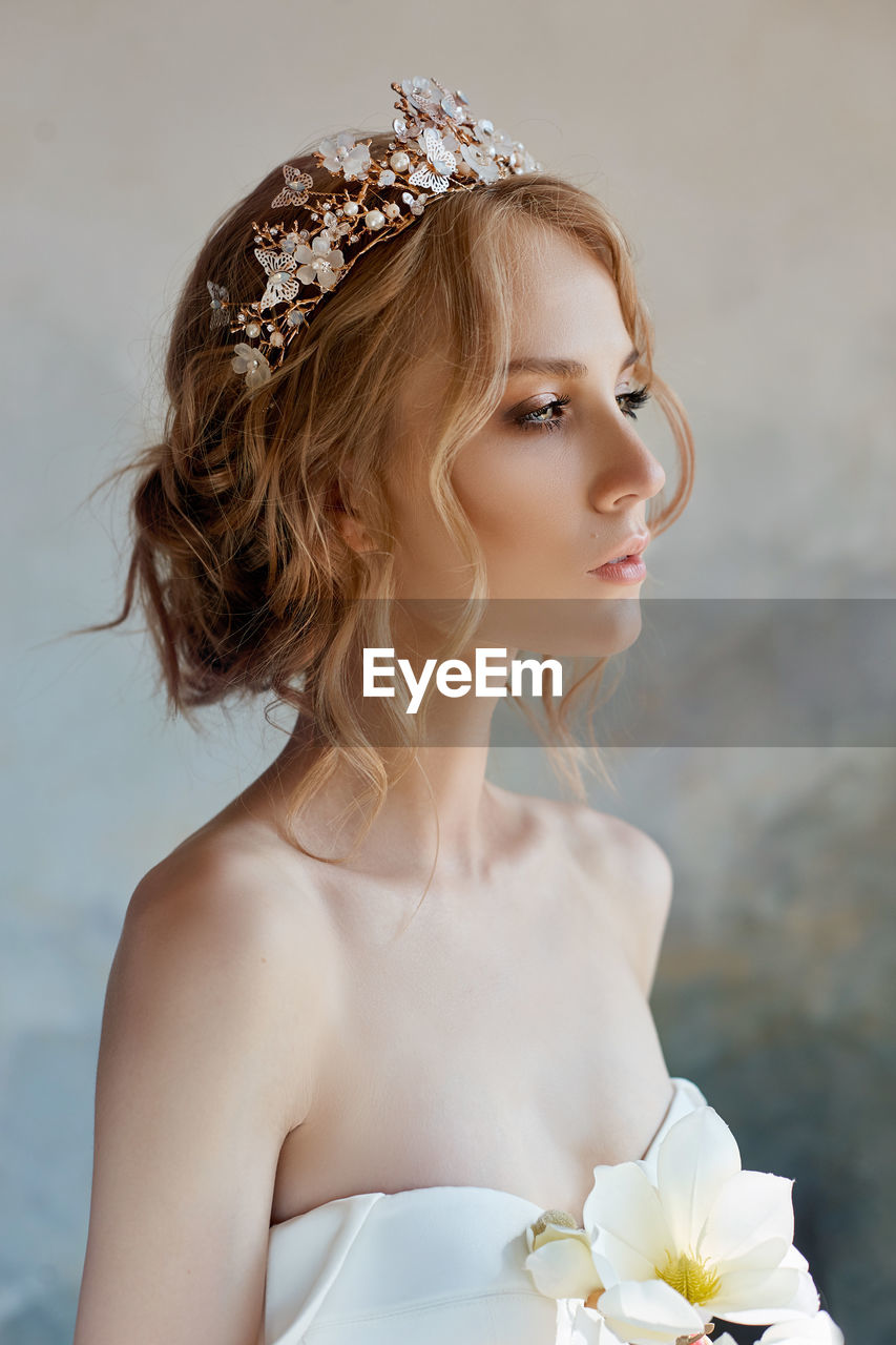 Close-up of bride looking away standing by wall