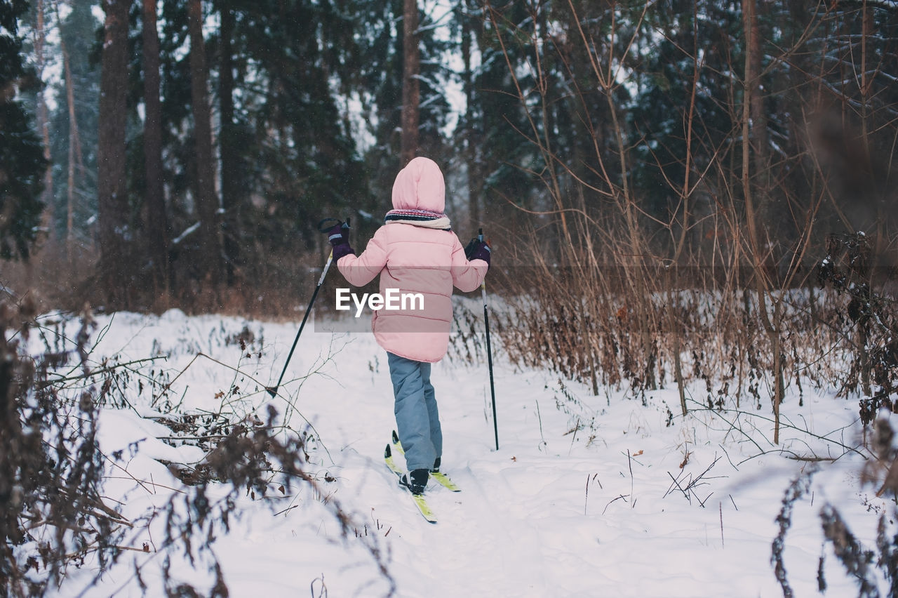 WOMAN STANDING ON SNOW COVERED LAND