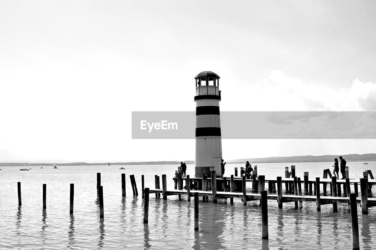 LIGHTHOUSE AMIDST SEA AGAINST SKY