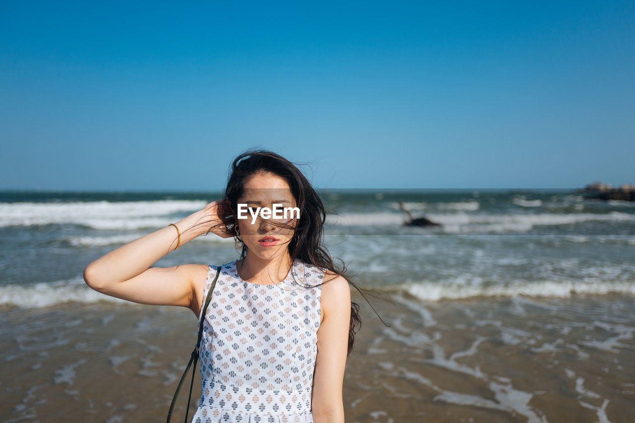 Portrait of woman standing at beach