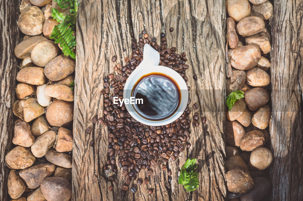 Directly above shot of coffee cup on roasted beans