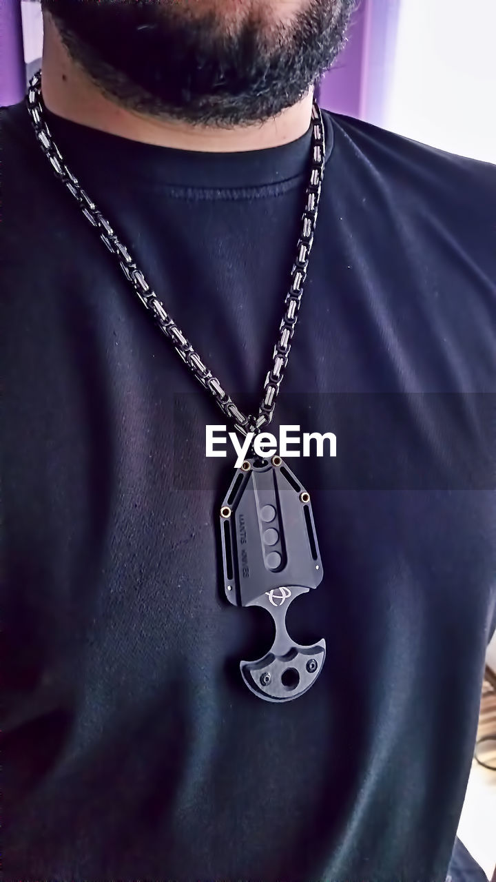 Midsection of young man wearing necklace