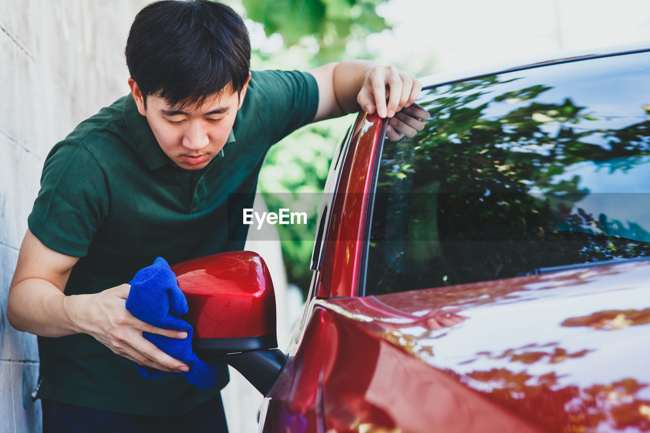 Close-up of man cleaning car outdoors