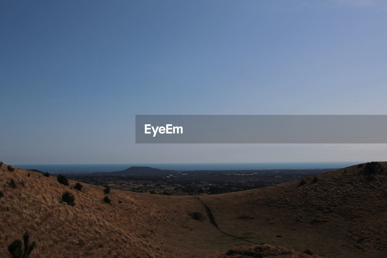 SCENIC VIEW OF ARID LANDSCAPE AGAINST CLEAR SKY