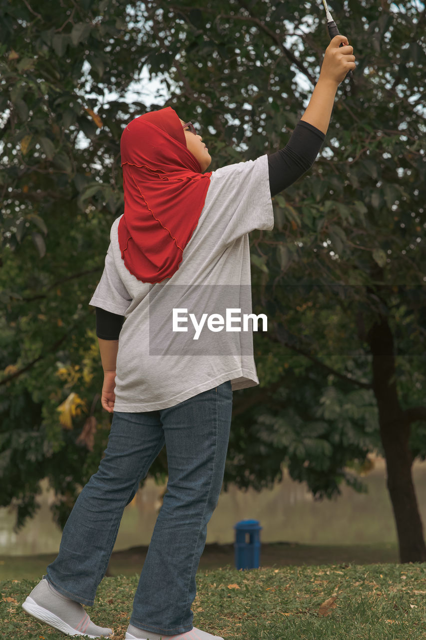 Young hijab asian girl playing badminton at the park.